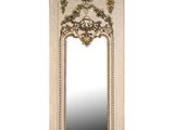 un miroir blanc avec un cadre doré et un motif ouvragé