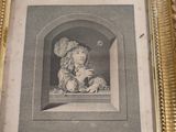 an old picture of a child in a gold frame on a table