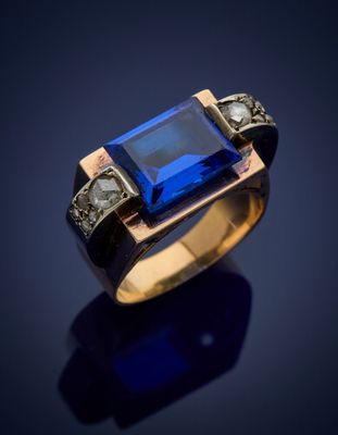 a close up of a ring with a blue stone in it
