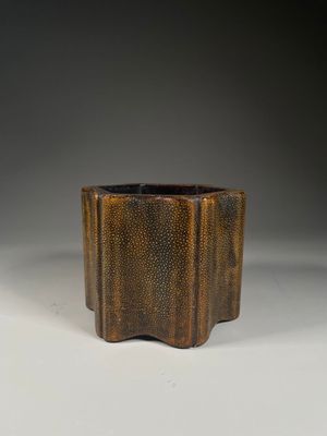 a brown vase sitting on top of a white table