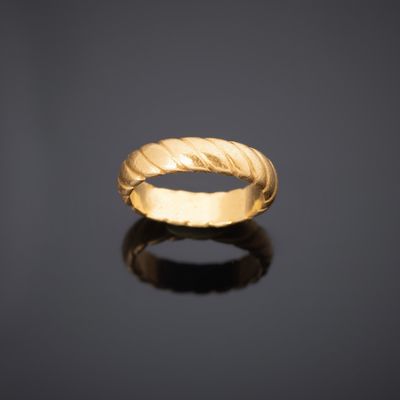 une bague en or au motif torsadé sur un fond noir