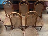 six chairs in the middle of a room with a table in the background