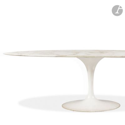 une table à manger ovale en marbre avec un piètement blanc