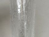 a person holding a clear glass with a pattern on it