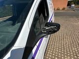 a white car with a purple stripe parked in a parking lot