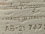 a close up of a white leather bag with writing on it