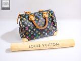a louis vuitton bag and a bat on a table
