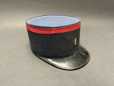 un chapeau noir orné d'un ruban rouge sur le dessus