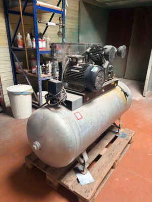 a large air compressor sitting on a pallet in a warehouse