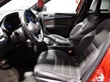 the interior of a red car with black leather seats and a steering wheel