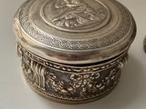 a silver box sitting on top of a table next to a spoon