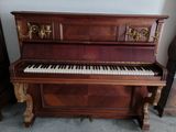 un piano qui se trouve dans le coin d'une pièce