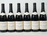 six bouteilles de vin sont alignées sur une table