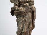 une statue ancienne d'une femme tenant un bébé dans ses bras