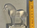 a plastic horse that is standing next to a ruler