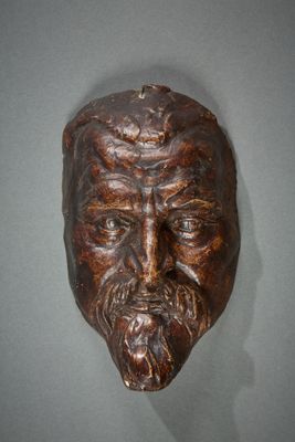 sculpture représentant un homme barbu et moustachu, fixée au mur