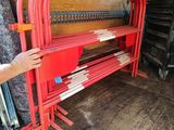 a man that is standing next to a red bench