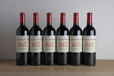 six bouteilles de vin rouge sont alignées sur une table en bois