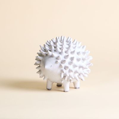 un petit hérisson blanc qui se tient debout sur une table