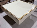 une table basse blanche aux bords dorés dans un entrepôt