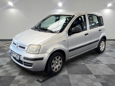 la petite voiture blanche est garée dans la pièce au sol en damier
