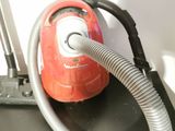 a red vacuum that is sitting on top of a black table