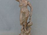 statue en bronze d'une femme tenant un oiseau sur un socle en marbre