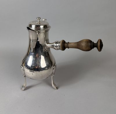 an antique silver coffee pot with a wooden handle on a stand