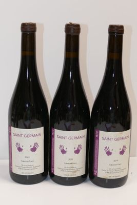 trois bouteilles de vin posées sur une table l'une à côté de l'autre