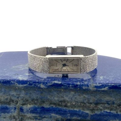 an image of a wrist watch sitting on top of a blue marble block