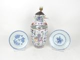 a blue and white vase and two plates on a table