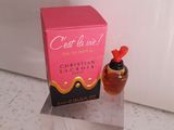une photo montrant un flacon de parfum posé à côté d'une boîte sur un comptoir