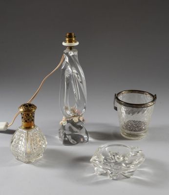 une bouteille en verre, un verre et un bougeoir en verre posés sur une table