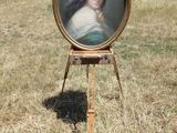 une image représentant un tableau d'une femme posée sur un chevalet dans un champ
