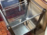 une table en verre avec un piètement en métal, placée dans une pièce