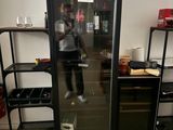 un homme debout devant un réfrigérateur dans une pièce