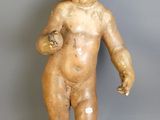 une petite statue représentant un garçon au bras cassé