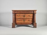 une petite commode en bois comportant trois tiroirs d'un côté et deux de l'autre