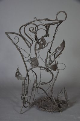 une sculpture métallique représentant une chaise sur laquelle est perché un oiseau