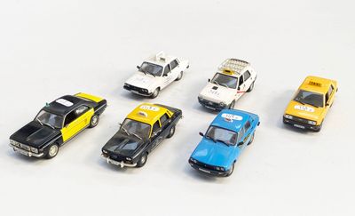 plusieurs petites voitures sont alignées sur une surface blanche