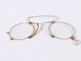pair of glasses on a white surface with a pair of glasses in the foreground