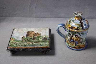 a small box with a painting on it next to a coffee pot