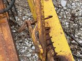 a close up of a yellow tractor on the ground