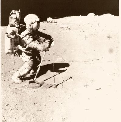 une vieille photo d'un astronaute marchant sur la Lune avec une pelle