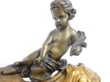 a statue of a little boy sitting on top of a clock