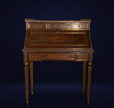 an antique writing desk with a wooden top and gold leaf decoration