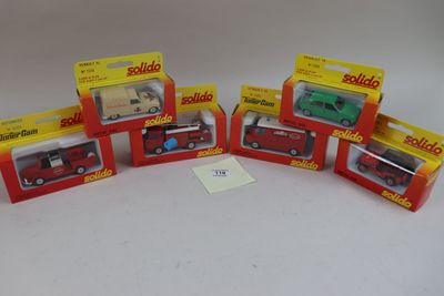 six véhicules miniatures assortis, emballés dans leurs boîtes, posés sur une surface blanche