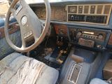 a dirty dashboard of a car with a wooden steering wheel