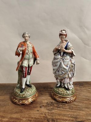 deux figurines représentant un homme et une femme posées sur une table en bois