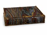 an old book with a marble cover sitting on top of a white surface